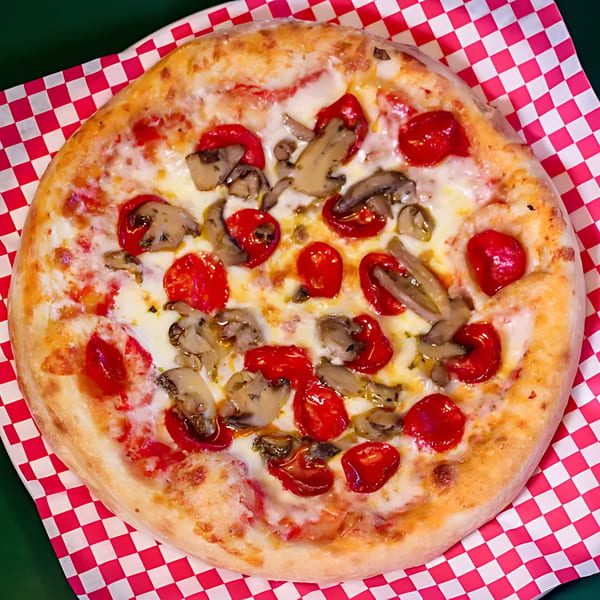 Original Brothers Pizza with mushrooms and red peppers on a red and white checkered paper.