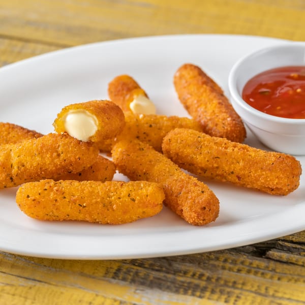 Golden-brown mozzarella sticks, one broken open to show melted cheese, served with a side of red sauce.
